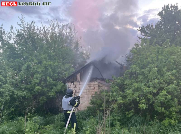 Рятувальник гасить господарчу споруду після ворожої атаки на Дніпропетровщину