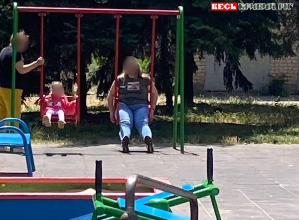 Доросла людина гойдається на дитячому майданчику в Кривому Розі